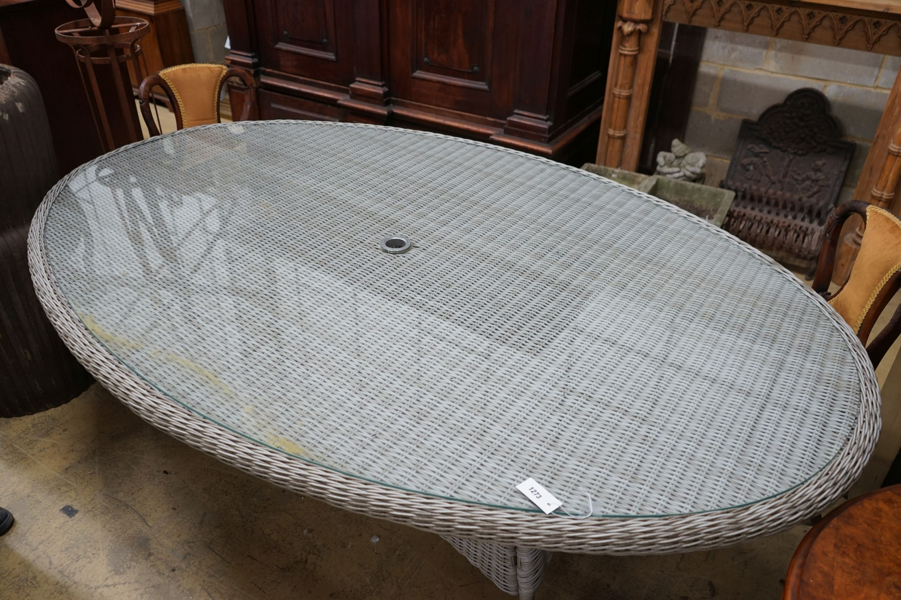 A Bramblecrest oval all weather rattan glass topped garden table, length 220cm, depth 144cm, height 73cm